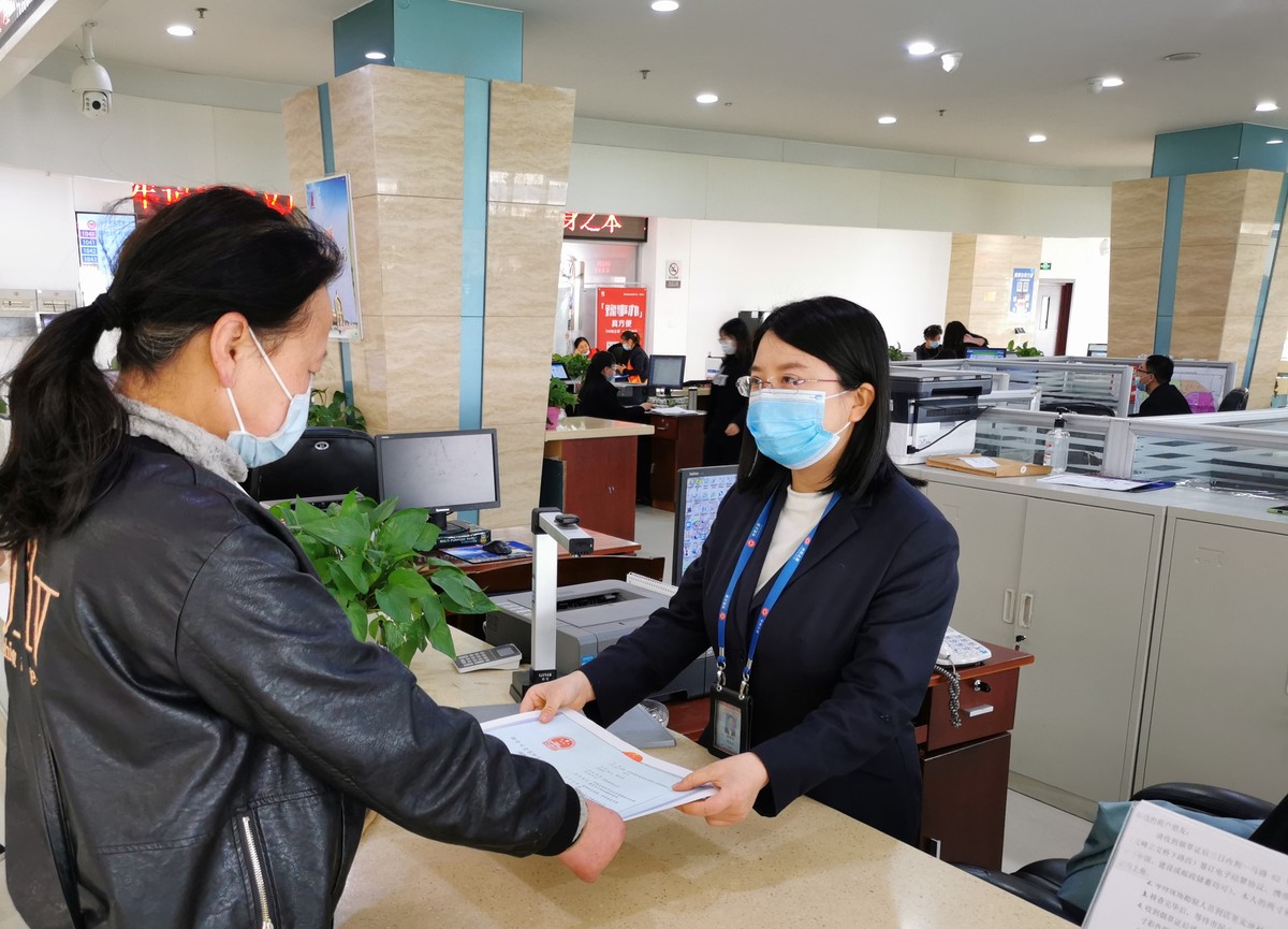 安阳市市民之家烟草专卖局窗口工作人员为商户办理手续 张俊军 摄